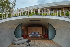 A stylish, industrial-style bedroom featuring concrete elements and modern furnishings.