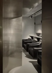 Modern industrial-style salon interior with metallic finish and sleek, minimalist seating.