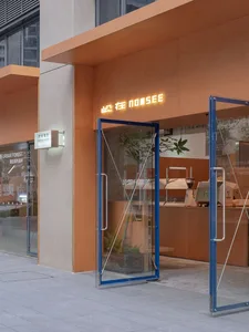 An image showing a modern retail storefront with large glass doors and metal frame.