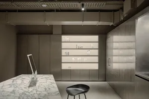 A minimalist medical office with a white marble desk and glass shelves displaying various medical products.