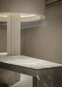 A modern interior featuring a marble and concrete countertop.
