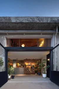 Concrete storefront with plants and warm lighting