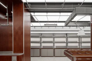 A modern library interior with metal shelves, wooden accents, and industrial lighting.