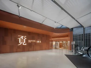 Modern bookstore interior with orange tiled walls and concrete flooring