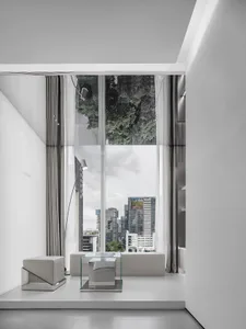 Modern minimalist interior featuring a glass wall with a cityscape view.