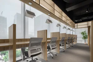 A spacious, minimalist office space with wooden desks and chairs.
