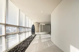 Clean, minimalist industrial-style lobby with concrete flooring and modern furniture.