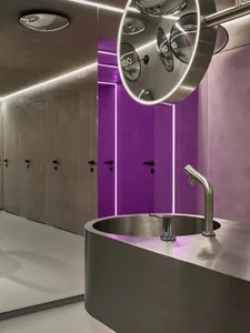 A modern bathroom with a metal sink and purple accents