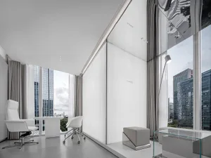 Modern office interior featuring concrete walls and white furniture.