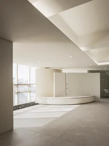 A minimalist office reception area with concrete flooring and seating.