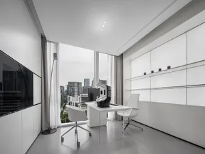 Minimalist modern office with white furniture, glass walls, and a metal desk.