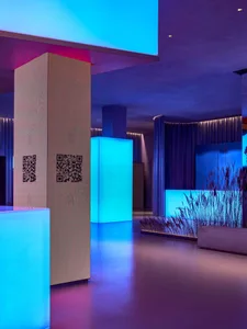 Indoor space with concrete pillars, fabric curtains illuminated by LED lighting
