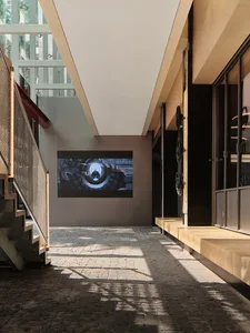 Staircase, glass wall, and industrial art in a modern interior setting.