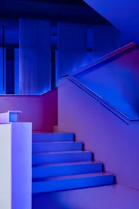 A modern staircase with a vibrant blue lighting design, featuring a colorful and contemporary aesthetic.