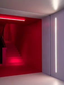 Red stairs with lighting panels in a minimalist interior design setting.