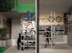 A workshop with metal shelves, bicycle parts, and people working on bikes.