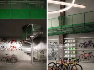 Bike shop interior with concrete floor, glass display cases, and metal bike frames mounted on the wall.
