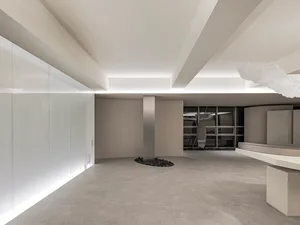 A minimalist office interior featuring a concrete floor and walls.