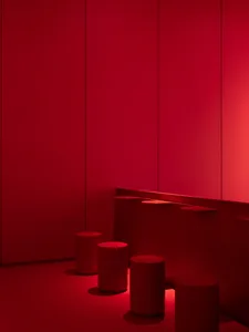 Minimalist room with metallic stools and red walls