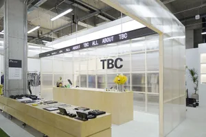Modern retail storefront with transparent panels, concrete slab, and wood accents.
