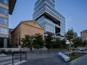 Modern office space featuring concrete walls, glass windows, and steel accents.