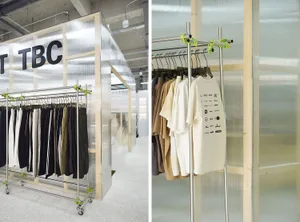 A clothing display in a retail storefront, featuring metal racks and glass dividers.