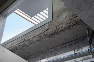 Exposed concrete construction details with visible reinforcing steel and concrete surface textures.