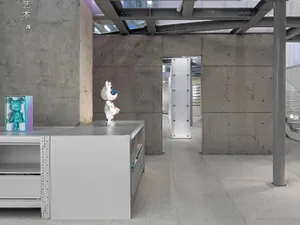An industrial gallery exhibition space with concrete walls and modern design elements.