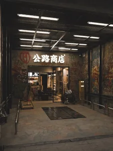 Concrete storefront wall with graffiti and lights.