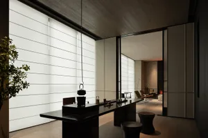 Modern minimalist coffee bar featuring dark wood tables and transparent glass elements.