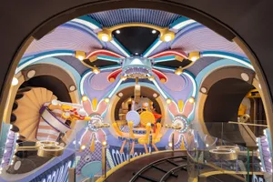An intricately designed indoor playground with a futuristic, extraterrestrial theme, featuring colorful lights and unique arc