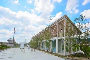 A modern house exterior with a wood-frame construction and large glass windows.