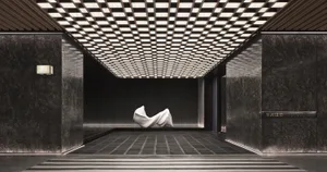 The entrance of a modern lobby with minimalist design, featuring marble walls and a concrete floor.
