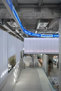 Modern office space with concrete walls, steel railings, and a concrete floor.