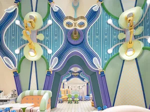 A vibrant, modern playroom with colorful plastic toys, wooden furniture, and fabric seating.