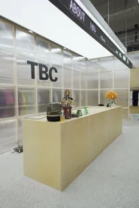 A modern reception counter with a minimalist design, featuring wood materials and various decorative items.