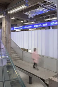 A modern retail space with concrete walls and glass railings.
