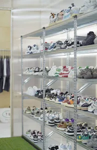 Metal shelves with various shoes displayed on them.