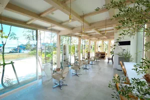 A contemporary hair salon with minimalist design, concrete flooring and walls, and natural light.