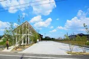 The exterior view of a modern residential building with a concrete facade and a spacious courtyard.