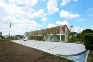 Modern building with concrete and glass exterior featuring large windows and a flat roof.
