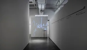 一件裝置藝術作品投影在極簡空間中的螢幕上。