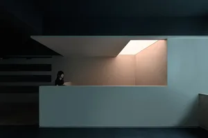 極簡大廳室內，混凝土牆面搭配天窗天花板。