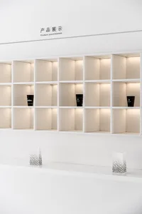 White, minimalist shelves displaying products with ambient lighting.