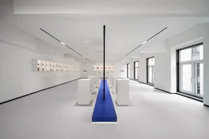 An empty minimalist retail store interior featuring white furniture and base.