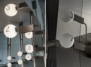 White circular signage with black numbers and metal arms against a modern, minimalist backdrop.