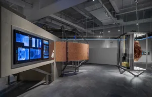 Modern exhibition space featuring glass, metal, and digital screens.