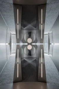 Modern interior design featuring a metal corridor with concrete flooring and a reflective ceiling, emphasizing minimalist des