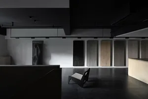 A minimalist interior space featuring wood panels and a modern chair on a polished floor.