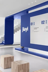 A modern minimalist office lobby with blue walls, white flooring, and wooden seating.